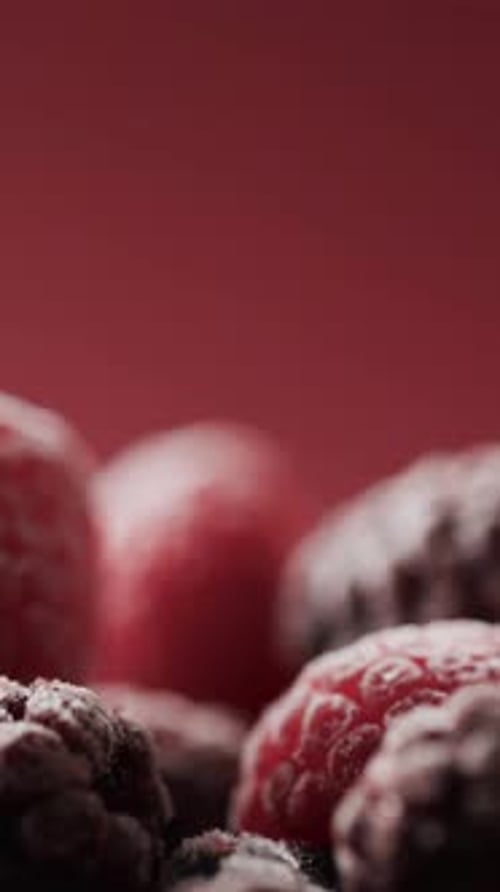 Micro vertical video close up of raspberries and copy space on red background