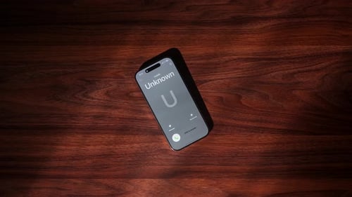 Smartphone with Unknown Caller on Wooden Surface Displayed Close Up