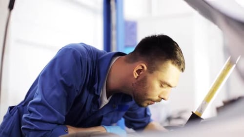 Autoservice-, Reparatur-, Wartungs- und Personalkonzept - Mechaniker mit Lampe