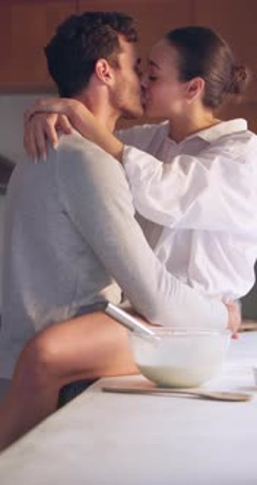 Affectionate Couple Embrace and Kiss in the Kitchen