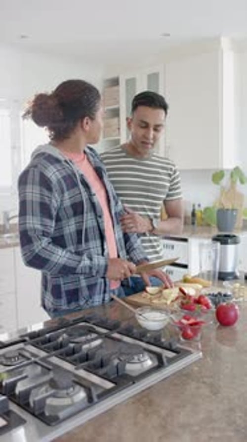 Woman Cuts Fruit as Man Looks On