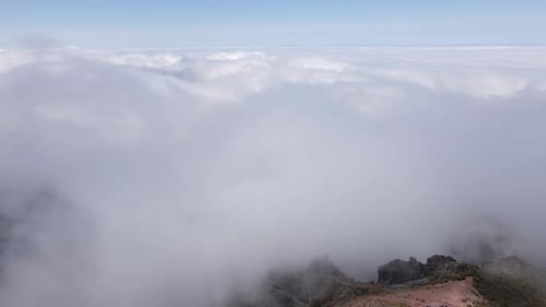 View of the clouds next to the mountain peak. Amazing view from above the clouds. Beautiful drone fo
