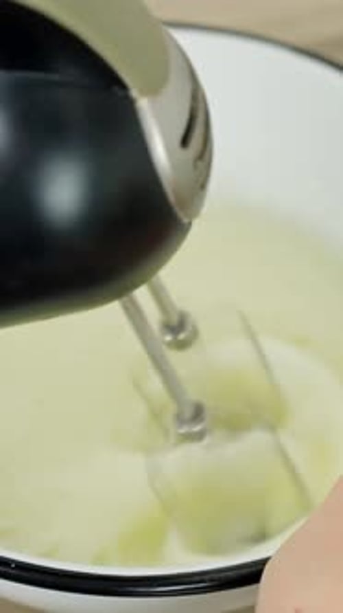 Primer plano de una batidora eléctrica batiendo claras de huevo para la receta de tiramisú