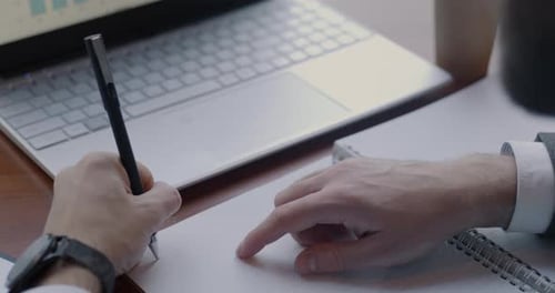 Adult Working and Taking Notes in Office