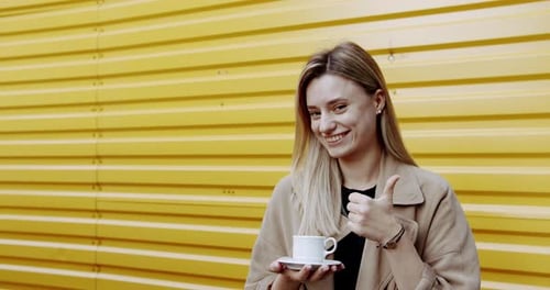 Young Woman Enjoying Coffee on Street