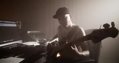 Musician Playing Bass Guitar in Sound Studio