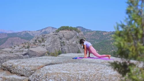 Woman Practicing Yoga Stretch in Nature with Mountain View Outdoors