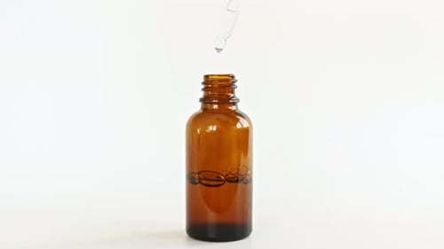 Dropper Slowly Dispensing Liquid Into Bottle