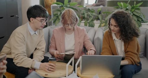 Kollegen diskutieren Ideen und zeigen auf den Laptop-Bildschirm bei der Arbeit im Creative Office