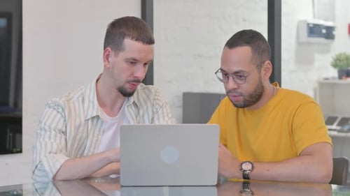 Two Men Looking at Laptop Together