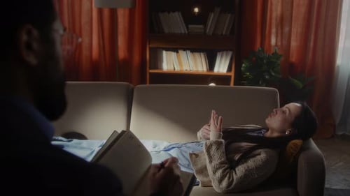 Une femme perturbée est allongée sur un canapé en faisant des gestes de la main pendant la conversation