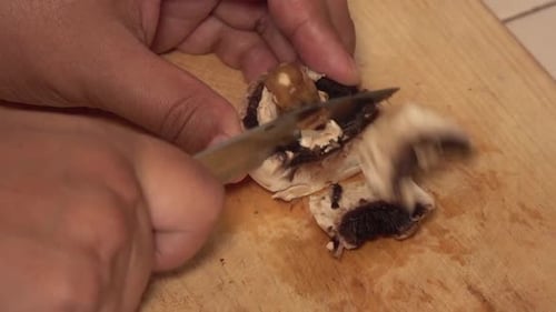 Lateral view of mushroom sliced on a cutting board.