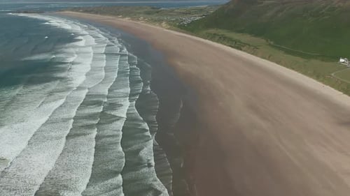 Dramatic Aerial View of Long Sandy Beach and Rolling Waves