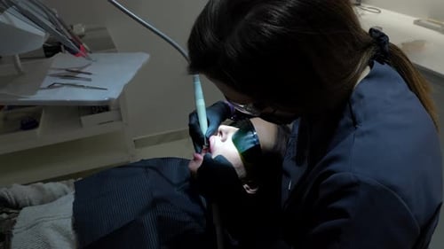 Dentist Performing Teeth Whitening Procedure on Patient