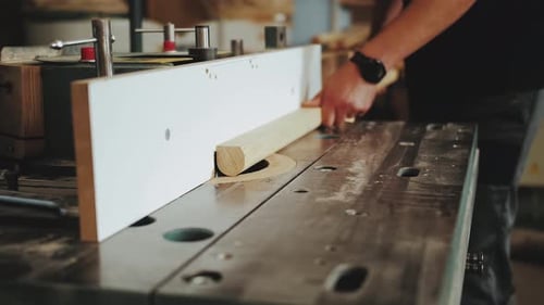 A Factory Worker Cuts Wooden Bars on a Circular Saw