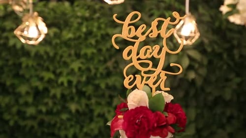 Wedding Cake with Best Day Ever Sign on Green Garden Decorated for Wedding Party at Night White and