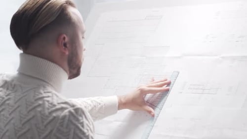 Concentrated Architect Works in Loft Using Drawing Board Workplace of Young Engineer in Modern