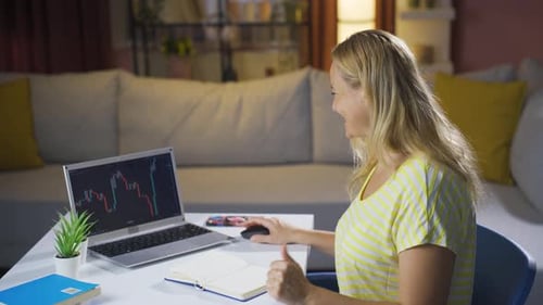 Woman Celebrates Stock Market Success on Laptop