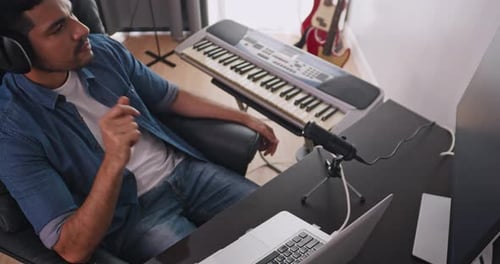 Man working in home music studio, playing keyboard