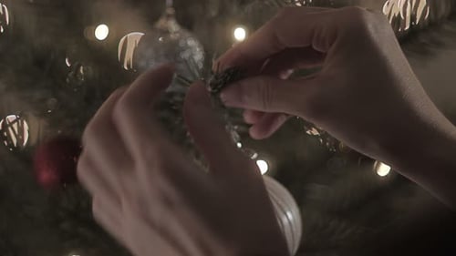 Woman Decorating Christmas Tree with Bauble Ornament
