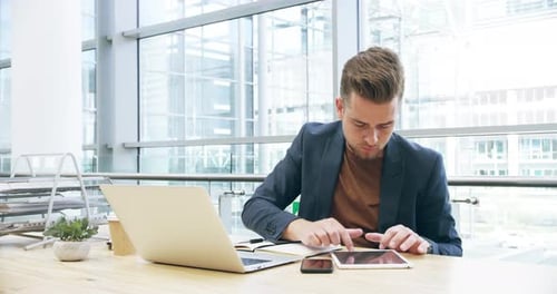 4k-Videomaterial eines gutaussehenden jungen Geschäftsmannes, der im Büro an seinem Laptop arbeitet