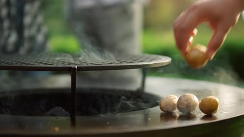 Closeup Unrecognizable Man Putting Potato On Grill On Backyard. Unknown Man Cooking Potato On Gra...