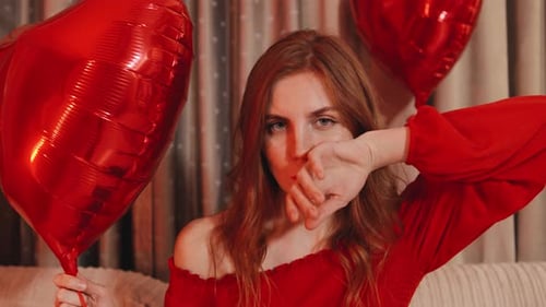 Sad Woman with Smudged Lipstick Holding Heart Balloons
