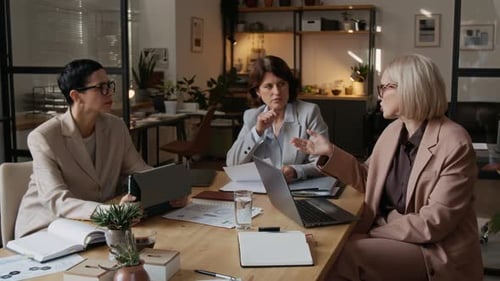 Three Middle-Aged Women Engaging in Corporate Meeting in Modern Office