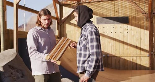 Video of diverse male skateboarders talking in skate park