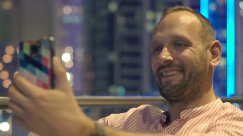Happy Man Taking Selfie Photo with Cellphone on Terrace in City At