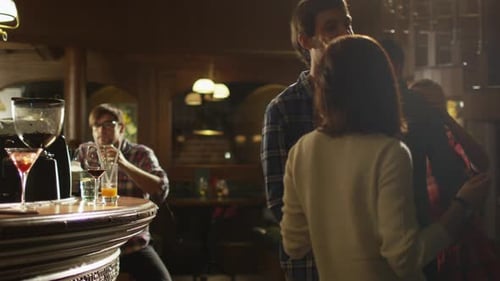 People are dancing while having a good time together at a bar.