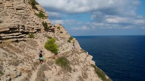 drone shot of me walking at some cliffs with beautiful views to the scenery and the ocean.