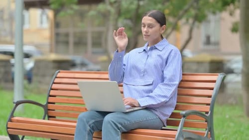 Woman Uses Laptop on Bench in the Park