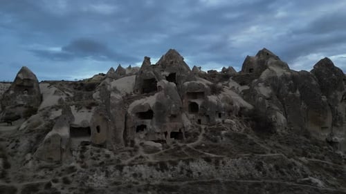 Historical Stone Caves Against Cloudy Sky In Cappadocia, Turkey. Aerial Shot