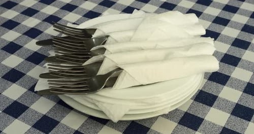 Stacked Plates with Napkins and Silverware Close Up