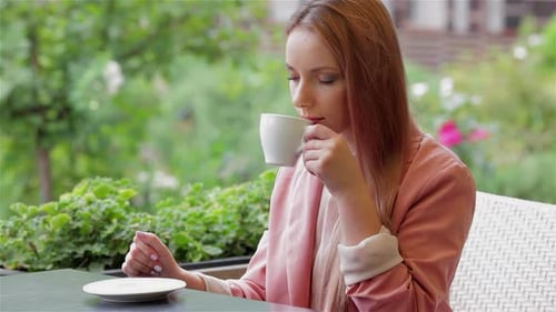Young Woman Savoring a Coffee Break at a Charming Cafe