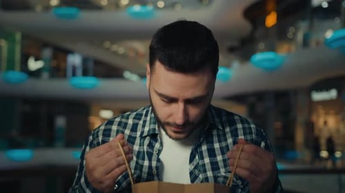 Man Opens Shopping Bag, Reacts with Surprise