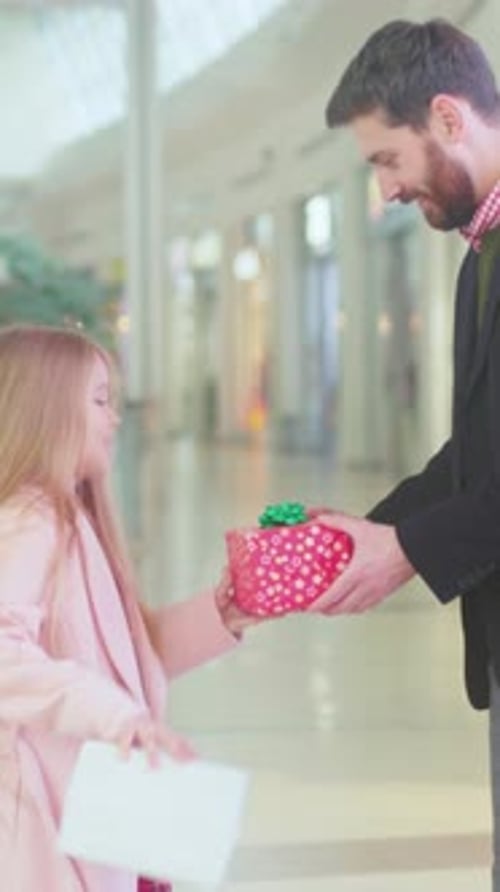 Heartwarming Scene of Family Exchanging Presents Joyful Father Daughter Exchange Amidst Festive Mall