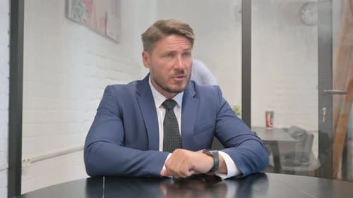 Man in Suit Sitting in Office Waiting