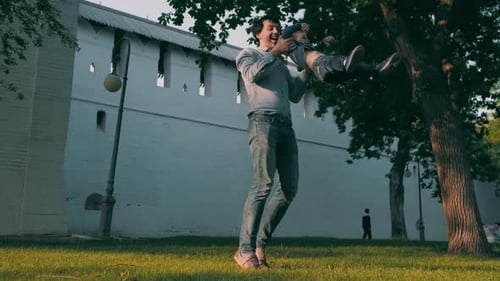 Father and Son are Playing in the Park Circles the Child Holding Hands Happy Family Slow Motion