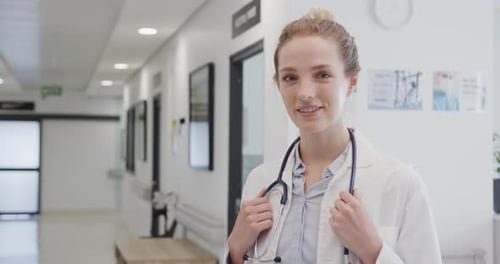 Portrait of happy female doctor with stethoscope smiling in hospital, in slow motion, copy space
