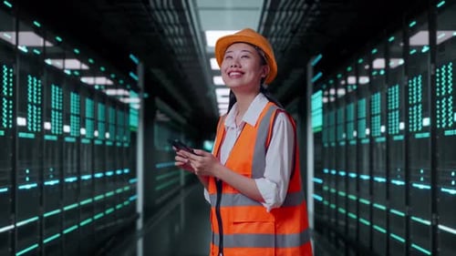 Side View Of Asian Female Engineer Using Smartphone in Data Center