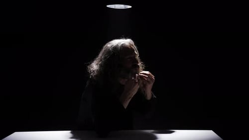 Older Man Speaking Under a Bright Light