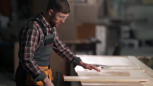 Craftsman Examining Wood in a Workshop