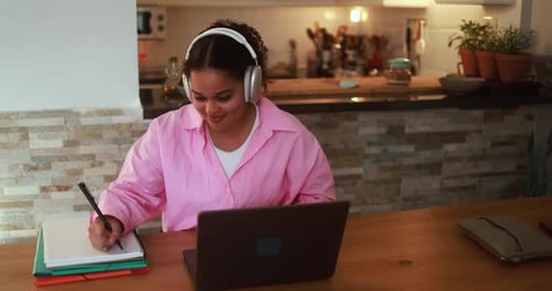 African girl using laptop computer at home while working on school project