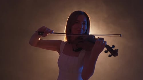 Woman Playing Violin in Dark Room with Bright Light