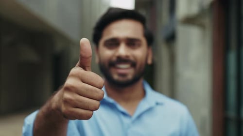 Portrait of Smiling Indian Man Gives Thumbs Up Gesture Standing on City Street
