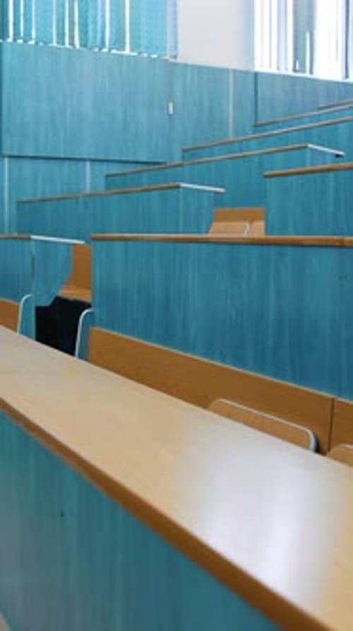 Sala de conferencias vacía. Auditorio con mesas y sillas de madera en el centro educativo
.