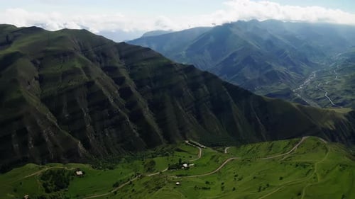 Lush Green Slopes with Terraced Fields Under a Cloudy Sky Verdant Mountainous Landscape with