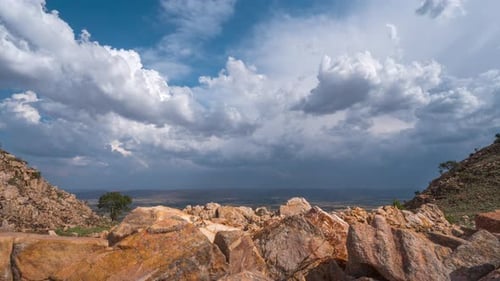 Beautiful outdoor motion timelapse of clouds as storm approaches in blue sky on rocky hill